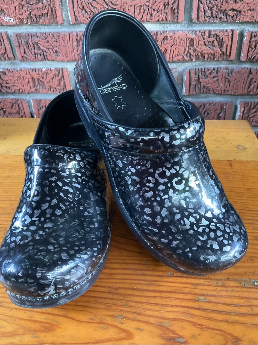 Dansko black clogs with pewter leopard print